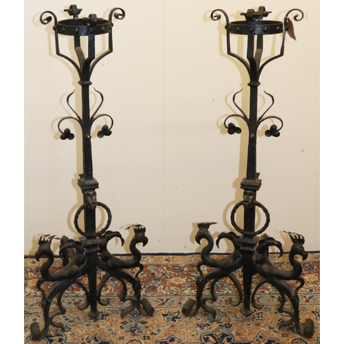 1391 - Pair of C19th style wrought iron fire dogs, with brazier basket finials on scroll, mask, ring and fl... 