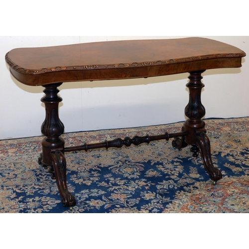 1330 - Victorian walnut centre table, figured shaped oval top with carved border, on carved baluster suppor... 