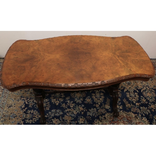 1330 - Victorian walnut centre table, figured shaped oval top with carved border, on carved baluster suppor... 