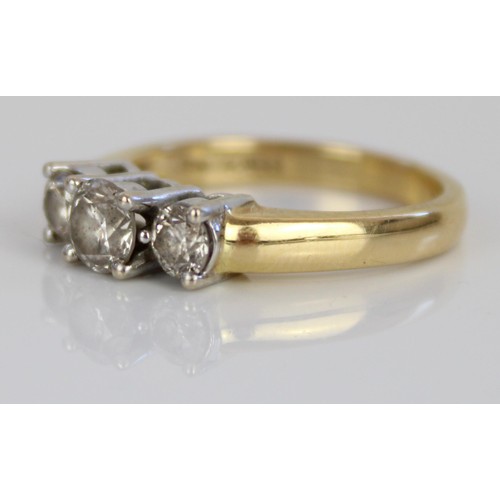 1007 - 18ct yellow gold three stone diamond ring, the central brilliant cut diamond flanked by two smaller ... 