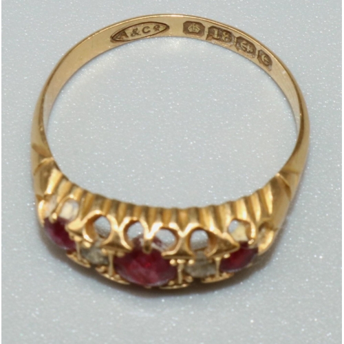 1023 - 18ct yellow gold five stone ruby and diamond ring, the three round cut rubies separated by two brill... 