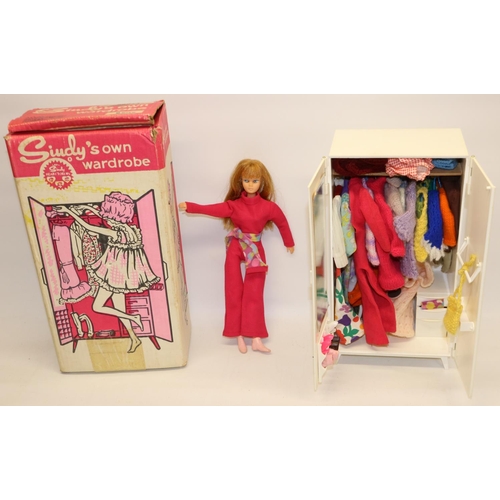 245 - Action girl doll in pink jumpsuit, and a Sindy 1968 wardrobe with original box, with a quantity of c... 