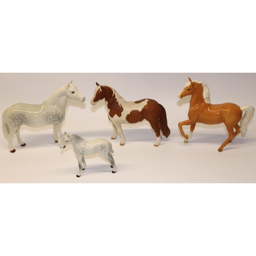 639 - Four Beswick horses: Skewbald Pinto pony No. 1373 in matt finish, Prancing Arab No. 1261 in palomino... 