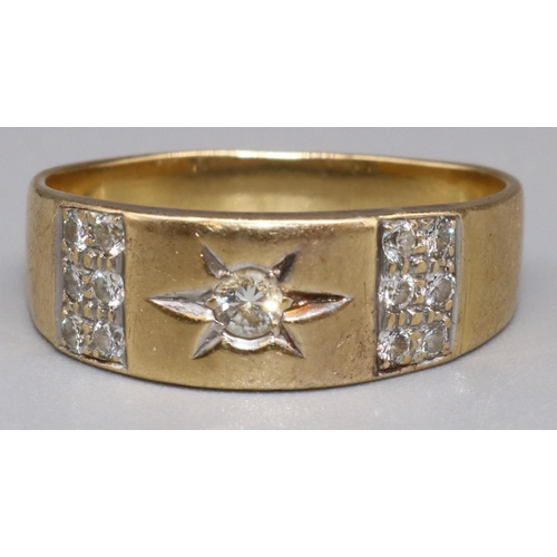 858 - Yellow metal ring with star set central diamond , flanked by diamond panels, size Q, 6.5g