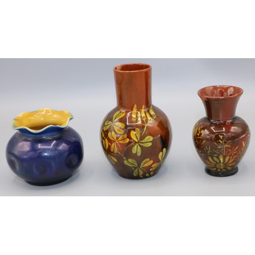 729 - Two Linthorpe pottery brown glazed vases, decorated with flowers, and a blue glazed globular vase bo... 