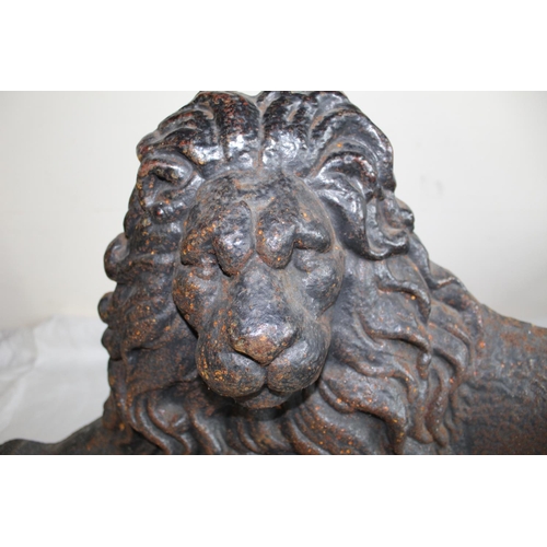 227 - Victorian black painted iron hearth ornament, cast as a recumbent lion, W68cm H35cm