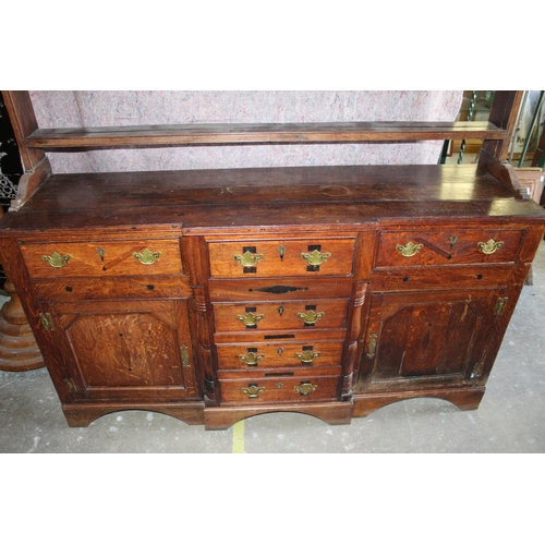 276 - Geo.1V oak breakfront dresser, with six drawers and two doors with brass handles on bracket feet, la... 