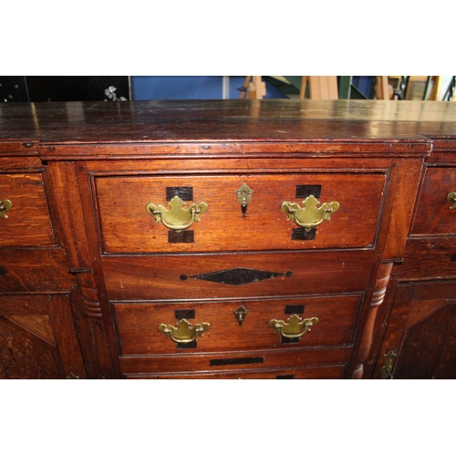 276 - Geo.1V oak breakfront dresser, with six drawers and two doors with brass handles on bracket feet, la... 