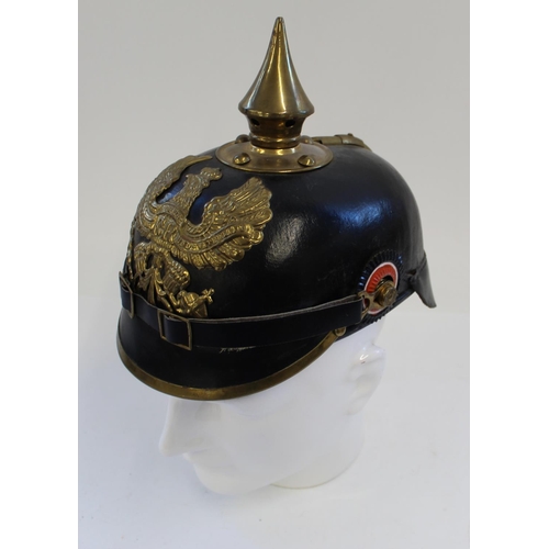 712 - Reproduction Prussian Pickelhaube. Black leather with brass spike and eagle plate. Complete with kha... 