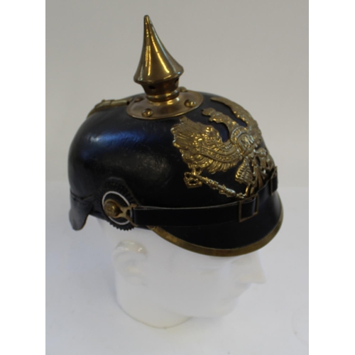 712 - Reproduction Prussian Pickelhaube. Black leather with brass spike and eagle plate. Complete with kha... 