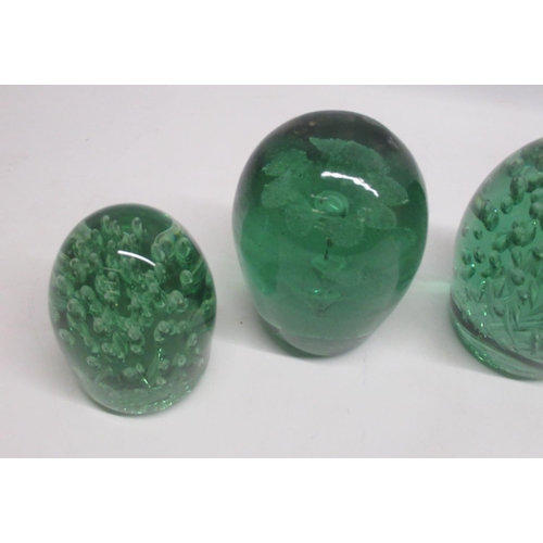 84 - Group of seven green glass dumps, four with internal flowers, max H13cm. a/f