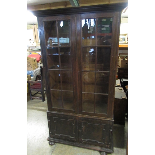 727 - C20th oak bookcase, with adjustable shelves and two glazed above two panel doors, on bun feet, W108c... 