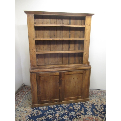 744 - Waxed pine dresser, with three shelves above two panel doors on skirted base, W132cm D34cm H185cm