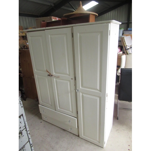 747 - White painted pine three door wardrobe with fitted interior and two drawers on bun feet, W135cm D54c... 