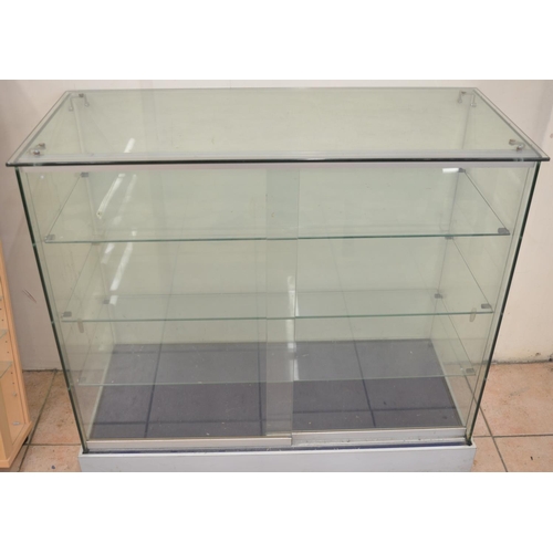 613 - Large glass shop display cabinet with 3 removeable shelves and sliding front doors. W101.7xD45.7xH91... 