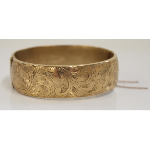 1234 - Hallmarked 9ct gold bangle, front engraved with scrolls and leaves pattern, internal width 6cm, 22.4... 