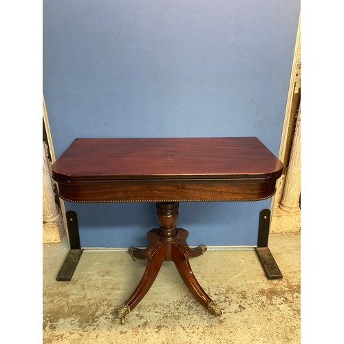 176 - George 1V mahogany tea table, swivel folding top on turned support and four sabre legs with brass ca... 
