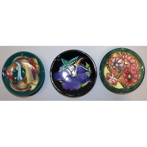 652 - Moorcroft Pottery: three pin dishes/coasters, comprising 'Cosmos' pattern signed by Philip Gibson an... 