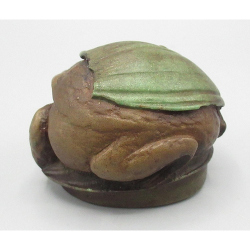 1274 - C20th Century Russian resin paperweight modelled as a frog sheltering beneath a leaf, marked beneath... 