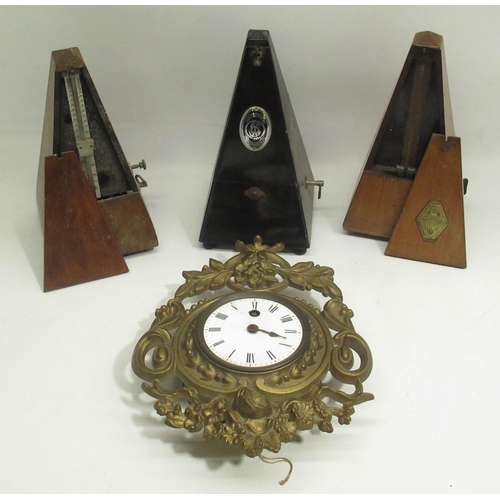 334 - Early C20th continental cast brass wall time piece with white enamel Roman dial and three metronomes