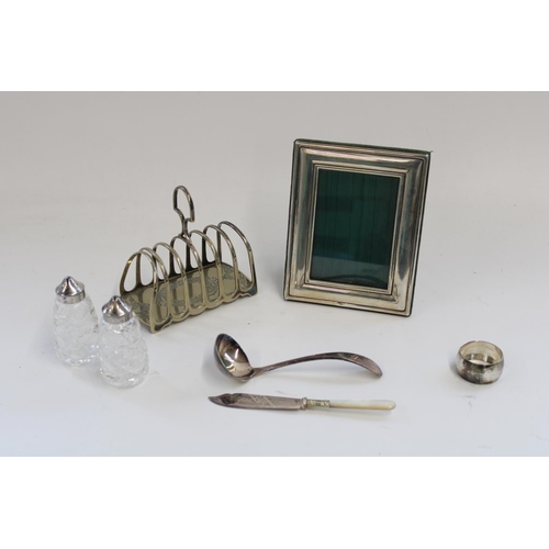 950 - White metal easel photo frame, W14cm, H18cm, a silver plated toast rack, salt and pepper etc.