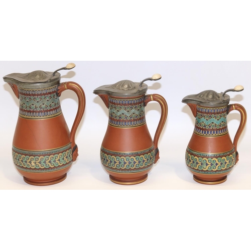 1282 - Christopher Dresser for Watcombe Pottery - set of three graduated terracotta jugs decorated with geo... 