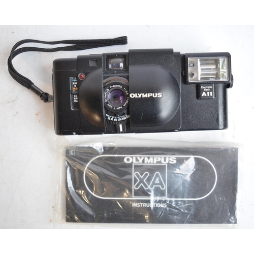 106 - Collection of 35mm film cameras and accessories to include an Olympus OM10 SLR with Olympus 28mm, 50... 