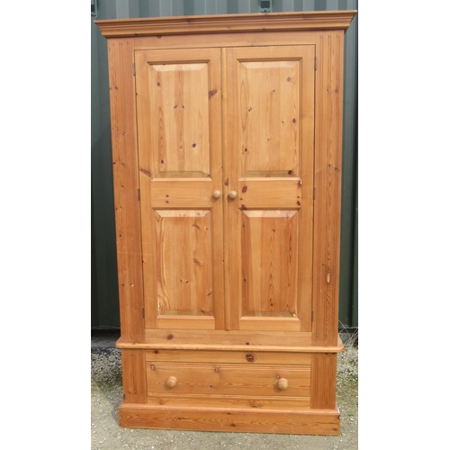 135 - Modern pine wardrobe, moulded cornice above two twin panel doors and a drawer with turned wooden han... 