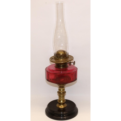 407 - C19th brass oil lamp with cranberry glass reservoir and black base, with chimney, lacking shade, H31... 