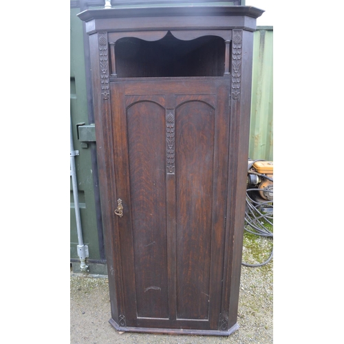 211 - C20th oak arts and crafts style hall corner wardrobe with carved floral motifs, open shelf above pan... 