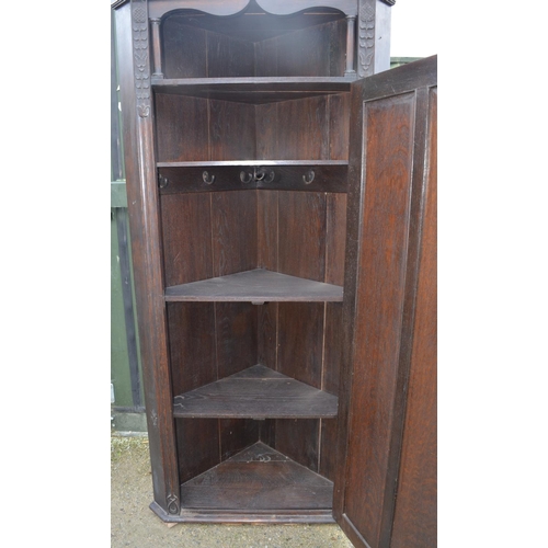 211 - C20th oak arts and crafts style hall corner wardrobe with carved floral motifs, open shelf above pan... 