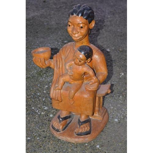 1364 - Wood carved figure of a man with fly swat (H71cm), another of a woman with child (H54cm) and a solid... 