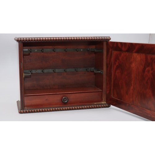 1152 - Early C19th figured mahogany table top key cupboard, with panel door and bead mouldings, interior wi... 