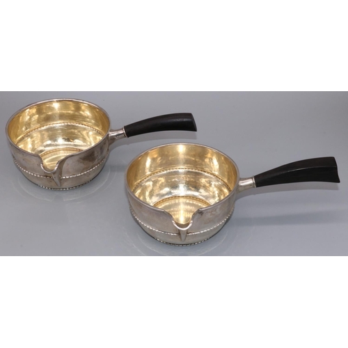 1083 - Pair of C20th Danish silver brandy pans circular bodies with spouts, beaded bands and black bakelite... 