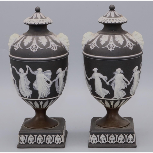 1110 - Pair of Wedgwood black jasperware urns and covers decorated with The Dancing Hours, twin mask handle... 