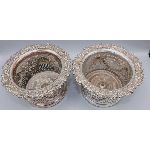 1087 - Pair of EP on copper Champagne bottle coasters, pierced bodies with lion masks and swags, scroll cas... 