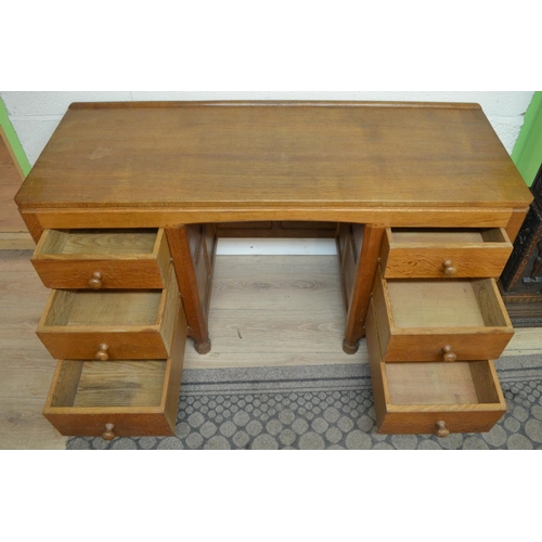 1482 - Robert Mouseman Thompson of Kilburn - an adzed oak panelled kneehole desk or dressing table, adzed t... 