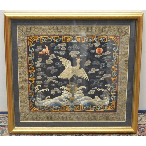 1158 - C19th Japanese silkwork panel, worked with a flying Crane and bats in clouds on a blue ground, in a ... 