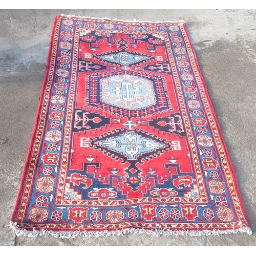 1315 - Red ground Caucasian rug with hooked triple lozenge medallion field in multi striped border, 260cm x... 