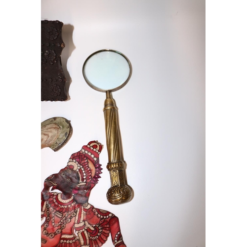 392 - Magnifying glass with brass handle, L30cm; two leather shadow puppets; two brass and enamel chargers... 