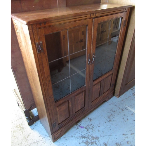 636 - Reproduction oak bookcase with two part glazed panel doors and adjustable shelves on bracket feet, W... 