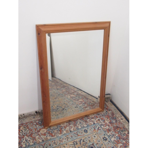 1048 - Wall mirror with upright bevelled plate in waxed pine cushion frame, H88cm W63cm