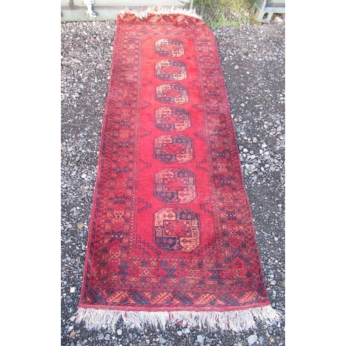 1210 - Eastern woollen red ground rug, field with seven octagonal medallions in multi repeating striped bor... 