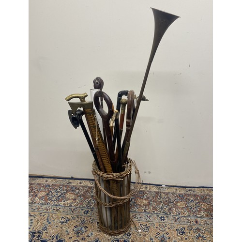 1042 - Wicker stick stand, collection of walking sticks, copper post horn etc.