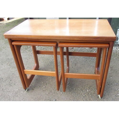 1060 - Mid century McIntosh triform teak nest of tables, with swivel folding rectangular top on shaped supp... 