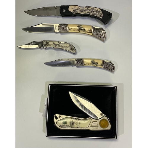 596 - Collection of presentation knifes of various sizes with scrimshaw style etching including stags, eag... 