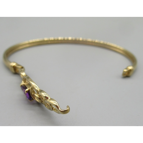 4 - 9ct yellow gold bangle with openwork front set with oval purple stone, the front opening with hook c... 