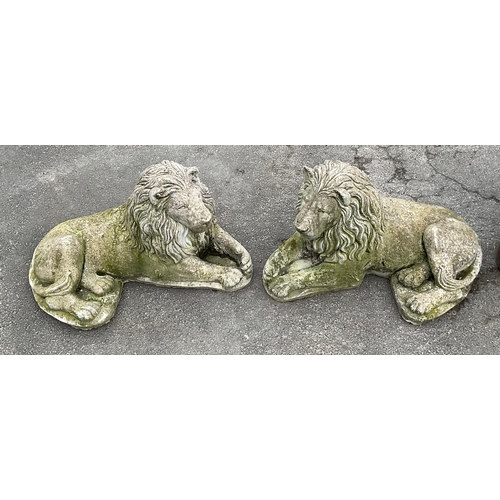 1248 - A Pair of reconstituted recumbent stone lions. Approx 66cm length