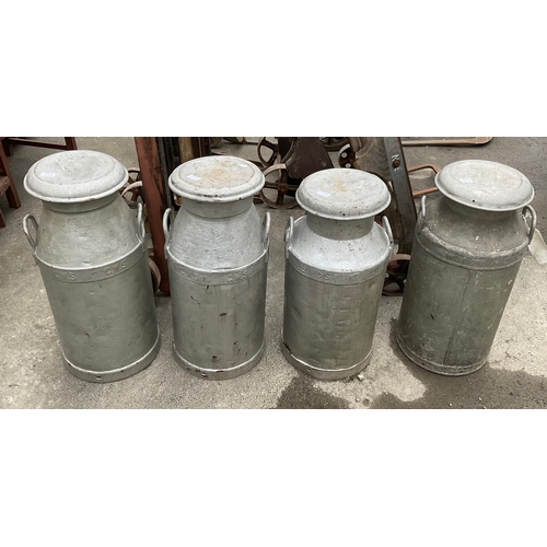 1249 - Four galvanised milk churns with lids and handles one by “United Co-op dairies ltd” and three by “CW... 