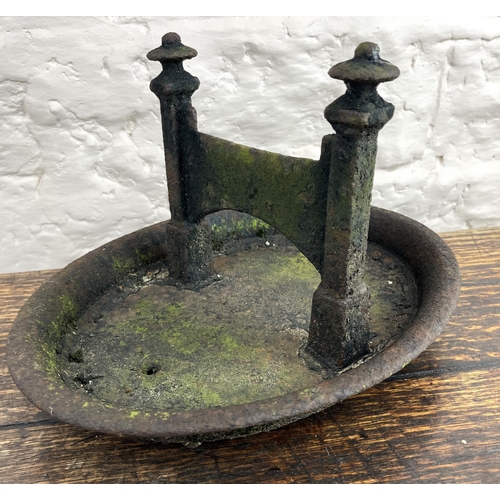 130 - Black painted cast iron boot scraper on oval base, L35cm